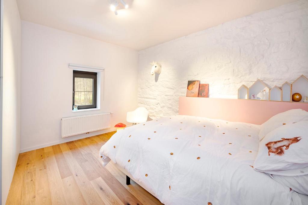 een witte slaapkamer met een groot bed en een raam bij Le Moulin de Bosson - Ourasi in Ferrières