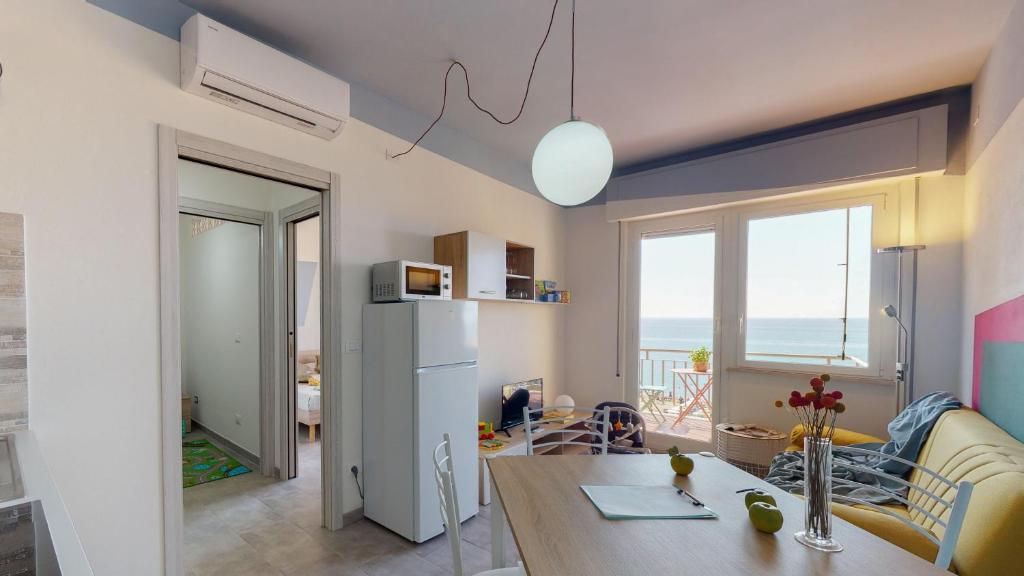 ピエトラ・リーグレにあるBabyaccommodation Family Panoramic Iのテーブルと冷蔵庫のあるキッチンとリビングルーム