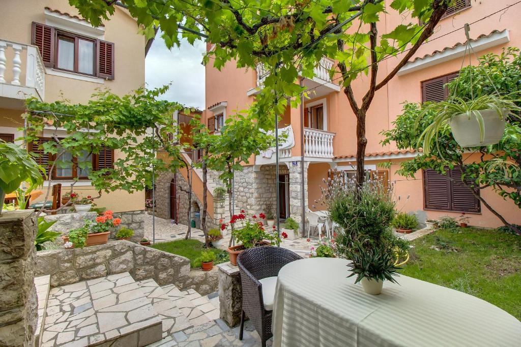 a patio with a table and chairs in front of a building at Biserka apartments near the beach and center in Mali Lošinj