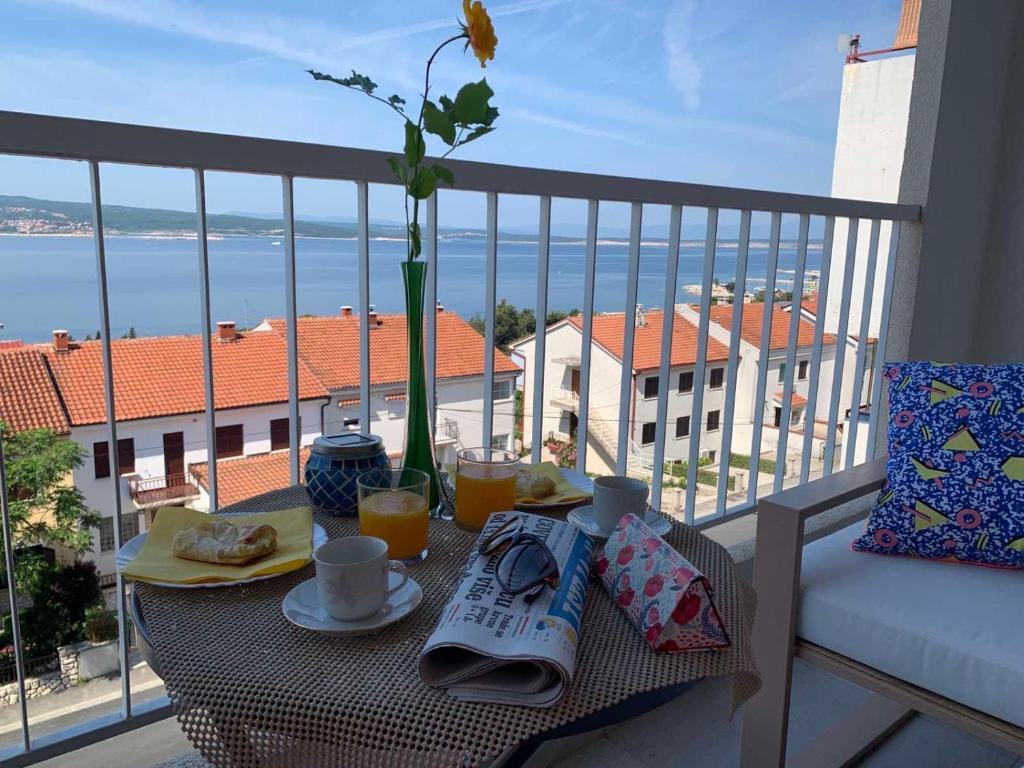 a table with food and drinks on a balcony at Blue View Apartment in Crikvenica