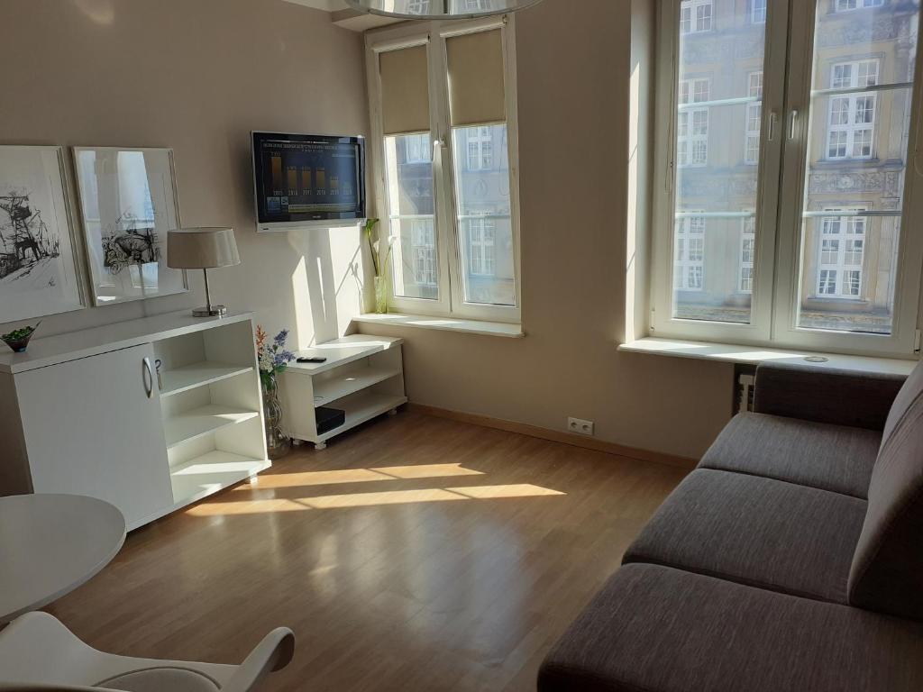 a living room with a couch and two windows at KWATERA in Gdańsk