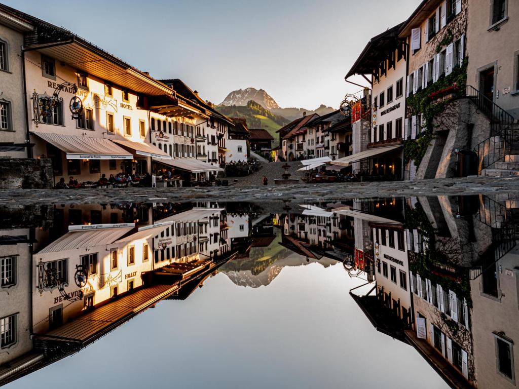 un reflejo de edificios en una masa de agua en La Fleur de Lys, en Gruyères