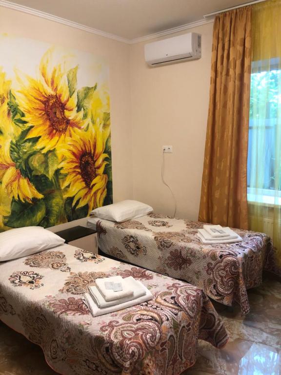 クラスノダールにあるMini-Hotel Lia Kubanの壁に絵画が飾られた部屋のベッド2台