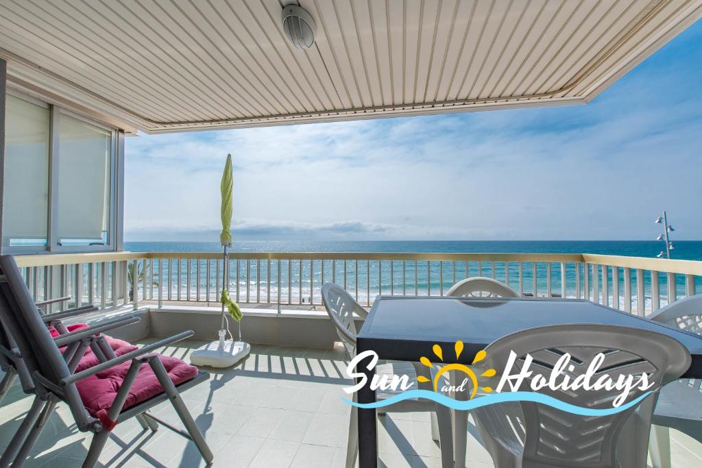 balcón con mesa, sillas y vistas al océano en Apartament R104, en Calafell