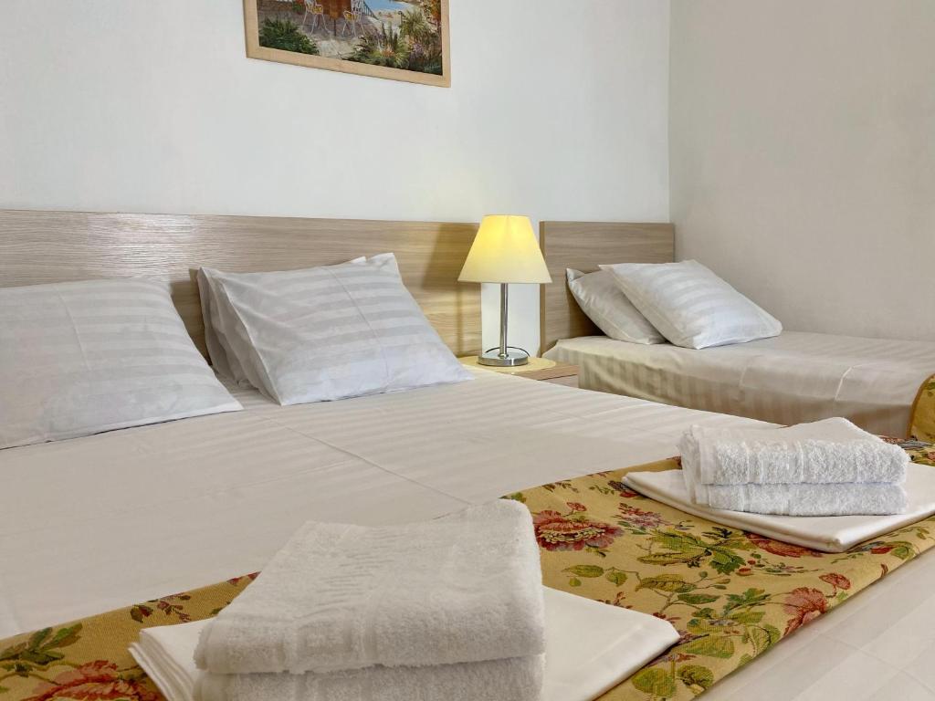 um quarto de hotel com duas camas e uma mesa em Tvoy Dom em Anapa