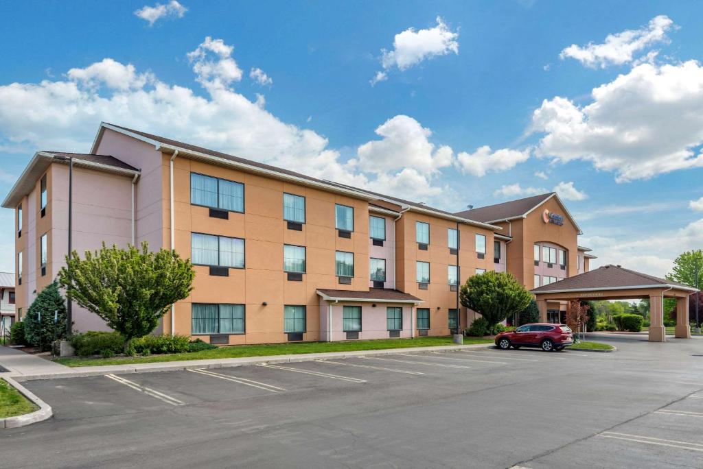 a building with a car parked in a parking lot at Comfort Inn & Suites Farmington - Victor in Farmington