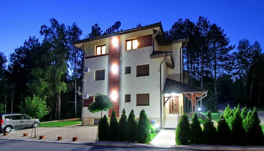 une maison avec une voiture garée devant elle dans l'établissement Apartman Oaza mira, à Zlatibor