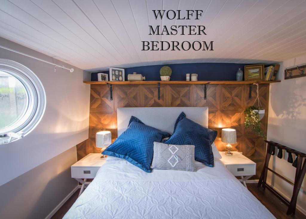 a bedroom with a bed with blue pillows at Barge At Titanic in Belfast