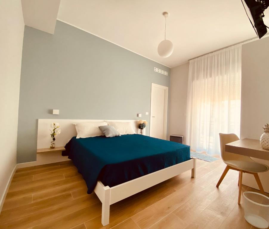 een slaapkamer met een blauw bed en een tafel bij B&b Quattro Tesori in Canicattì