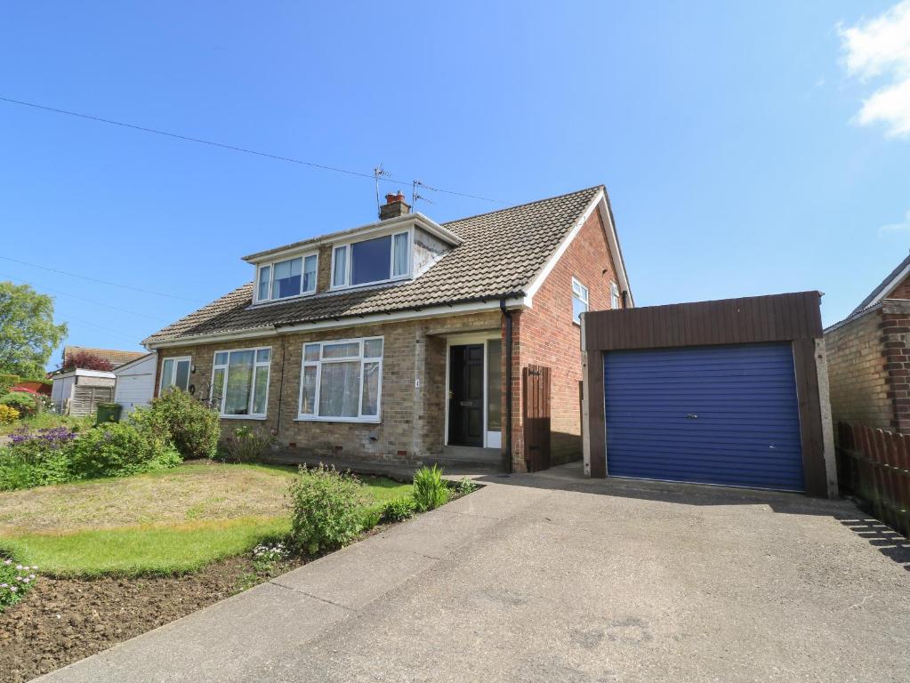 a brick house with a blue garage door at 4 Ranby Drive in Hornsea