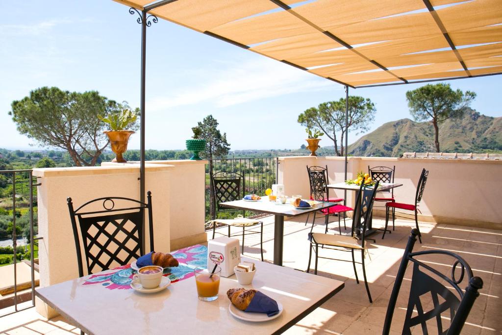 a table and chairs on a balcony with a view at Don Vittorio Country Village in Taormina