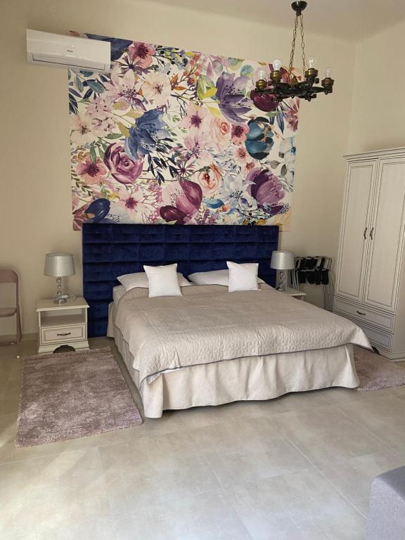 1 dormitorio con 1 cama grande y pared de flores en SenoRita2 Magánszállás, en Miskolc