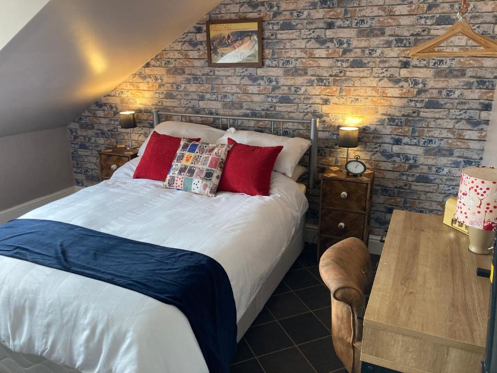 1 dormitorio con cama y mesa de madera en Trafalgar Retreat, en Scarborough