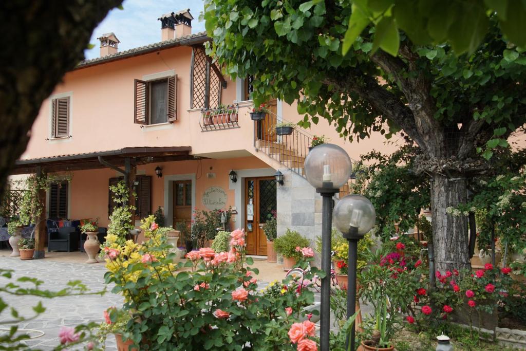 una casa con muchas flores delante de ella en Agriturismo L'Ulivo in Fiore, en Spoleto