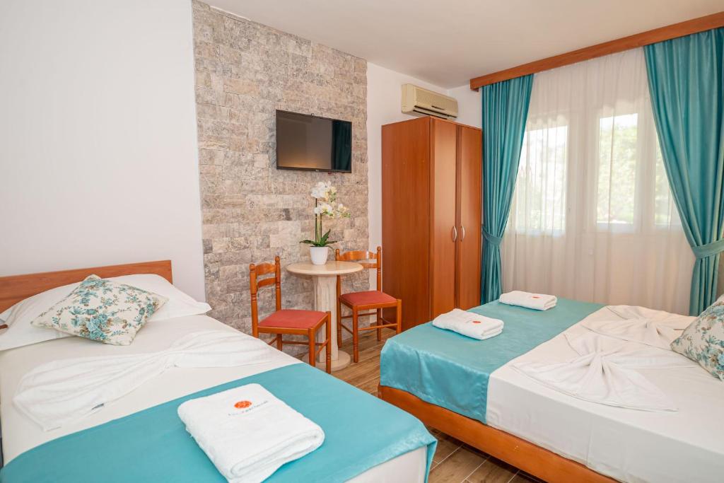 pokój hotelowy z 2 łóżkami i stołem w obiekcie Guest House S-Lux w Petrovacu na Moru