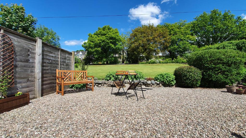 a patio with a table and chairs in a garden at Willows Cottage in Pitlochry