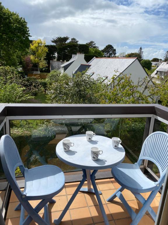 d'une table blanche et de deux chaises sur un balcon. dans l'établissement Confort équipés neuf 2 pas plage, à Carnac