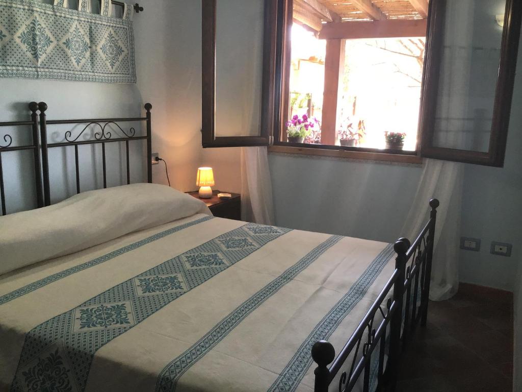 a bedroom with a bed and a window at Donna Violante Porto Corallo Affittacamere in Villaputzu