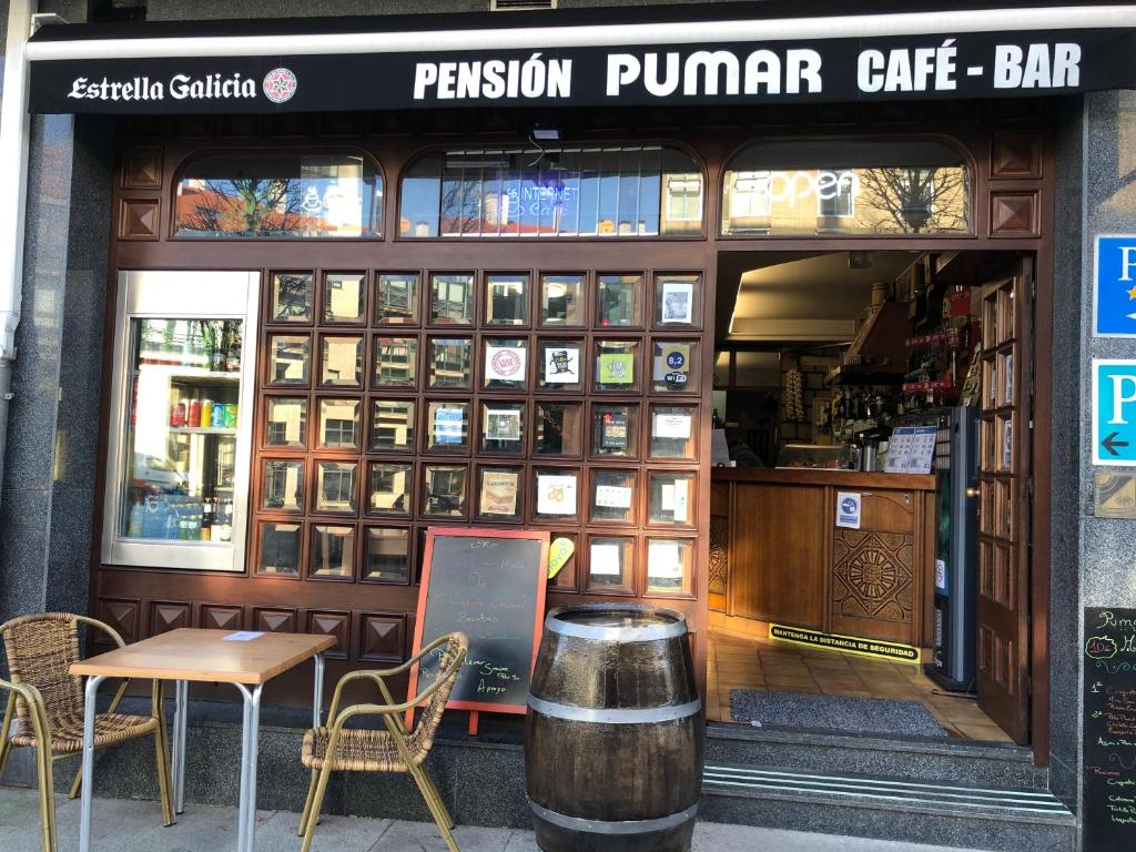 un restaurante con mesa y sillas frente a él en Hostal Pumar, en Santiago de Compostela