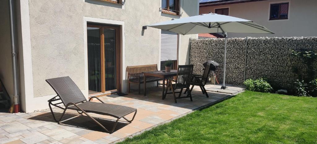 a patio with a table and chairs and an umbrella at Ferienwohnung Ponlach in Tittmoning
