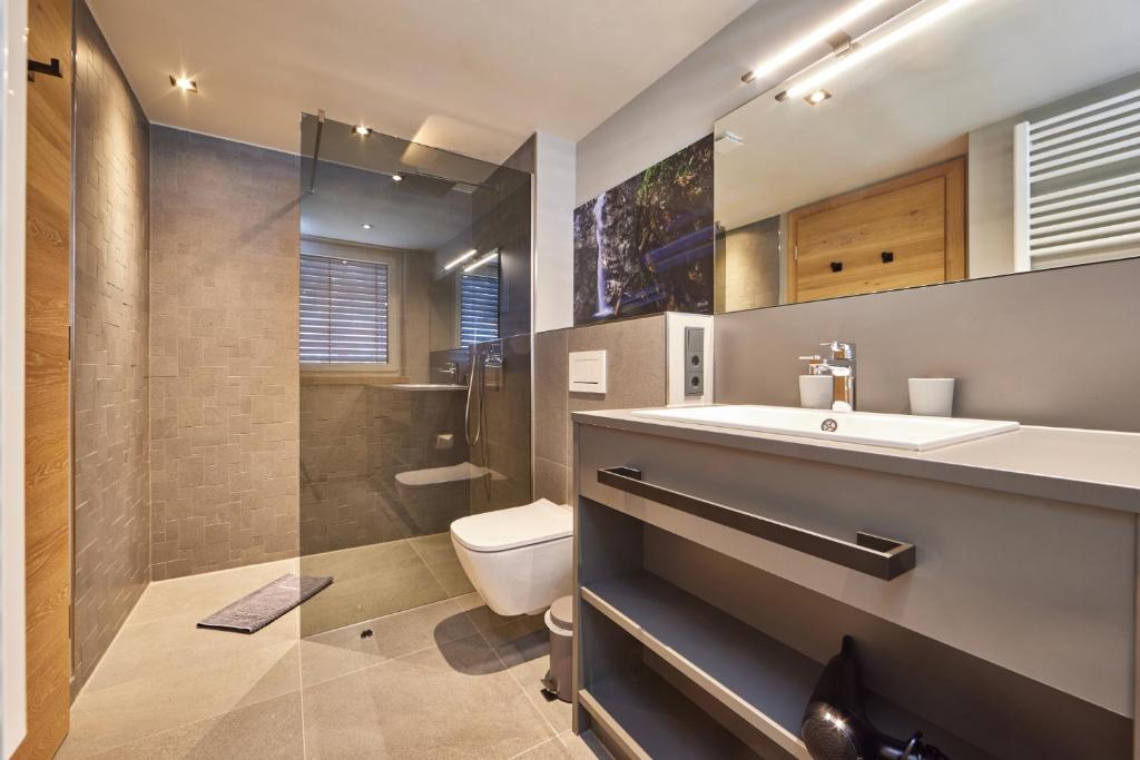 a bathroom with a toilet and a sink and a shower at moun10 urlaubswohnen in Garmisch-Partenkirchen