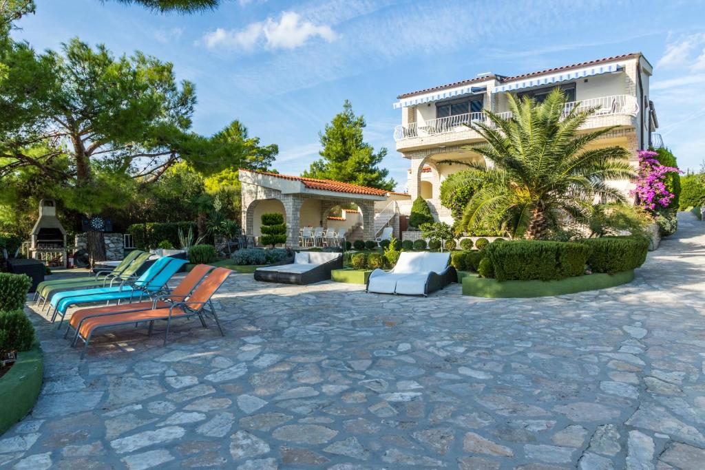 a patio with chairs and a house at Apartments Villa Punta Royal in Pirovac