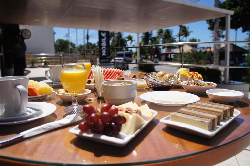 a table topped with plates of food and drinks at Nobile Suítes Tambaú in João Pessoa