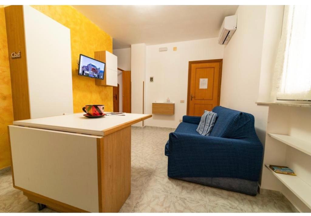 - un salon avec un canapé bleu et une table dans l'établissement Via San Giacomo piano rialzato, à Ustica