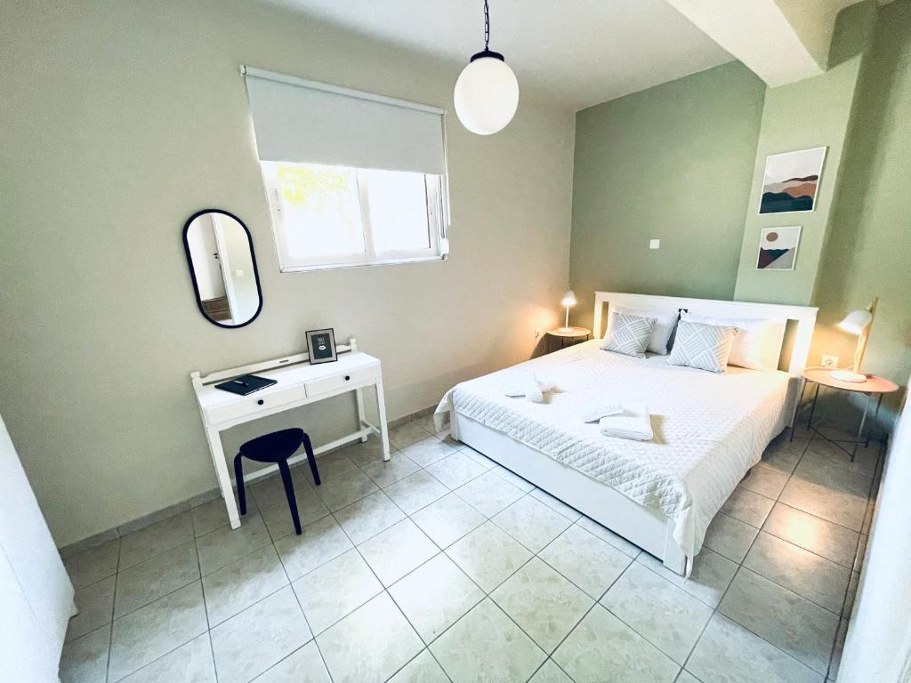 カラマタにあるSofi's Apartmentsのベッドルーム(ベッド1台、デスク、鏡付)