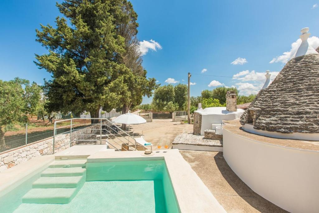 a swimming pool in the backyard of a house at Trullo Pioppo gigante - jacuzzi in San Michele Salentino