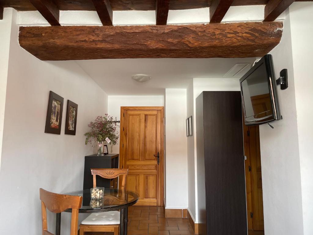 Habitación con mesa, TV y puerta. en Apartamento Corredera, en Córdoba