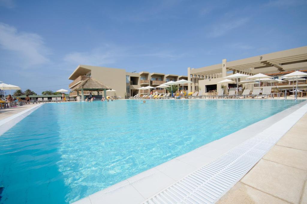 una gran piscina con agua azul y sombrillas en Oasis Salinas Sea, en Santa Maria