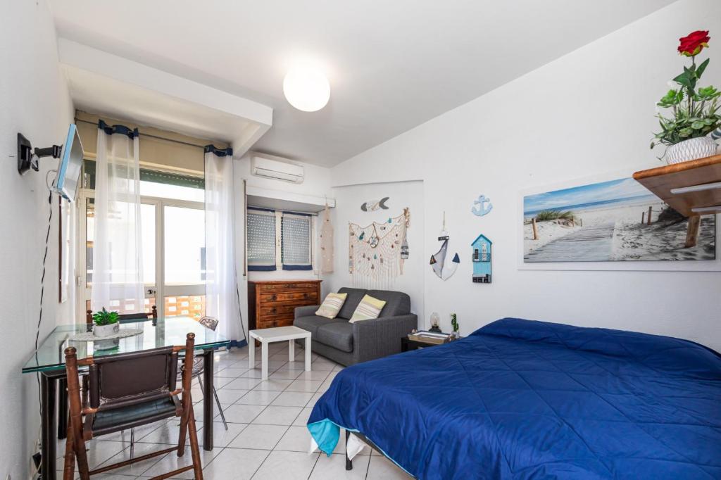 a bedroom with a blue bed and a couch at Roma Sea Dreaming in Lido di Ostia