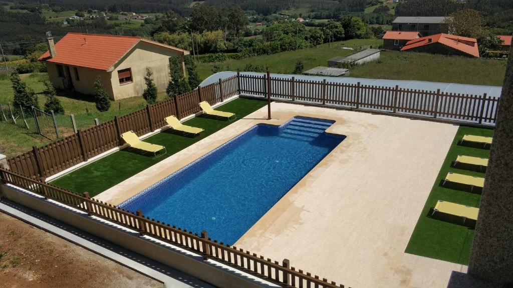 an overhead view of a swimming pool with chairs and a fence at Casa rural con piscina, Cedeira, San Román in Cedeira