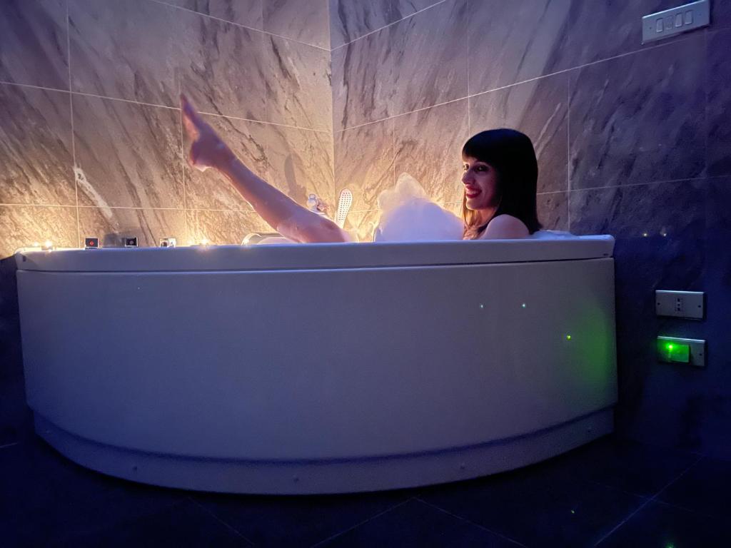 a woman in a bath tub in a room at DON GIL CHIC in Polignano a Mare