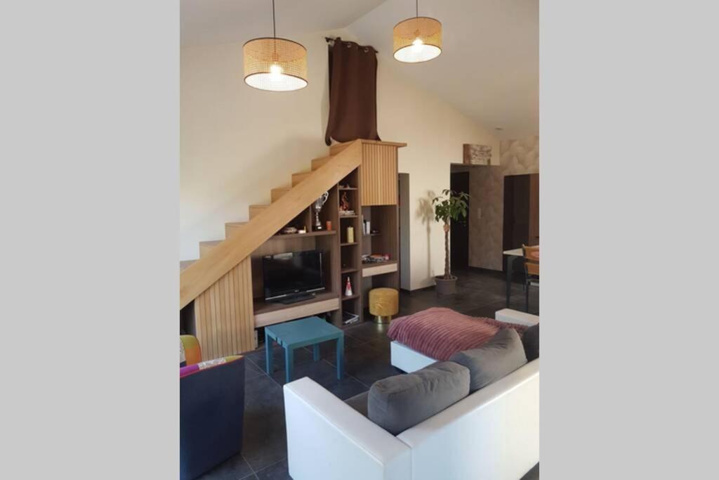 a living room with a couch and a staircase at VILLA Adrien , maison de charme. in Casanova