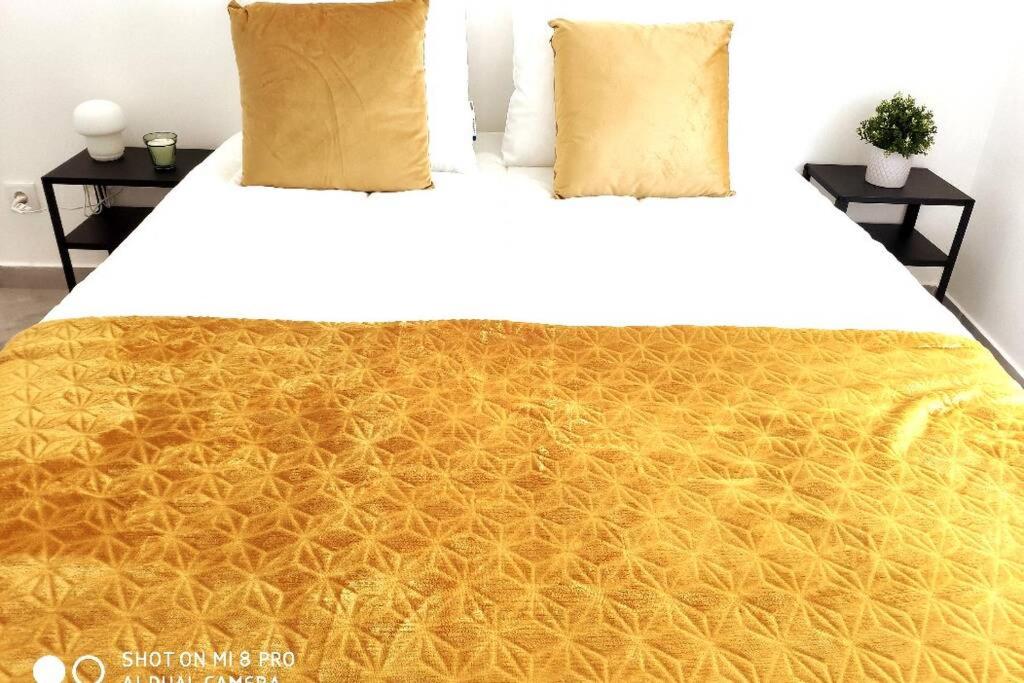 a bed with a yellow blanket on top of it at Old Town House in Loulé