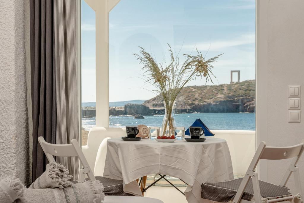 una mesa con un jarrón junto a una ventana en Grotta Sognare, en Naxos Chora
