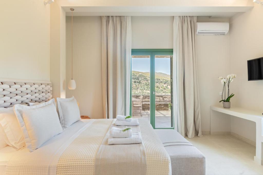Łóżko lub łóżka w pokoju w obiekcie Casa Di Fiori Andros Suites