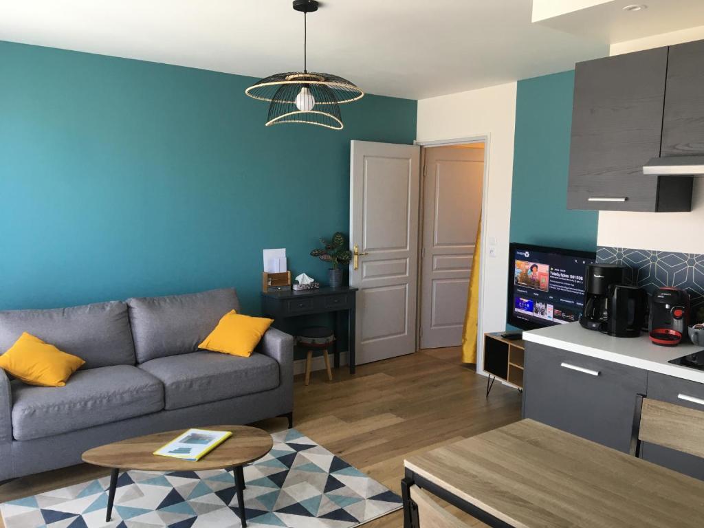 a living room with a couch and a table at Appartement tout équipé avec piscine proche Stade OL et EUREXPO in Meyzieu