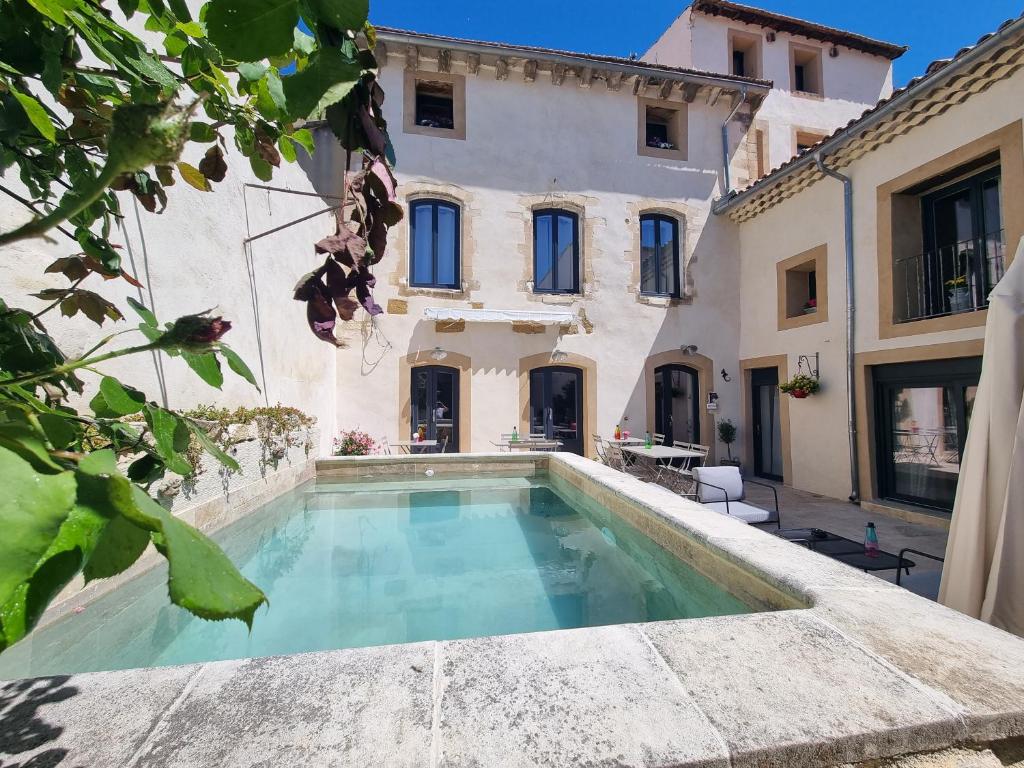 uma casa com piscina em frente a um edifício em La Bastide em Bédarrides