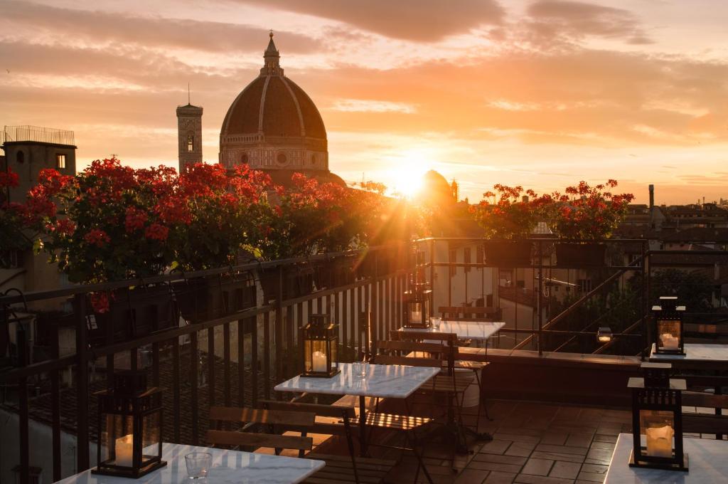 a balcony with tables and a view of a building at Hotel Cardinal of Florence - recommended for ages 25 to 55 in Florence