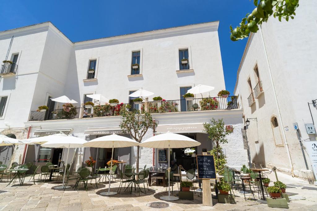 un edificio con mesas, sillas y sombrillas en Palazzo Indelli, en Monopoli