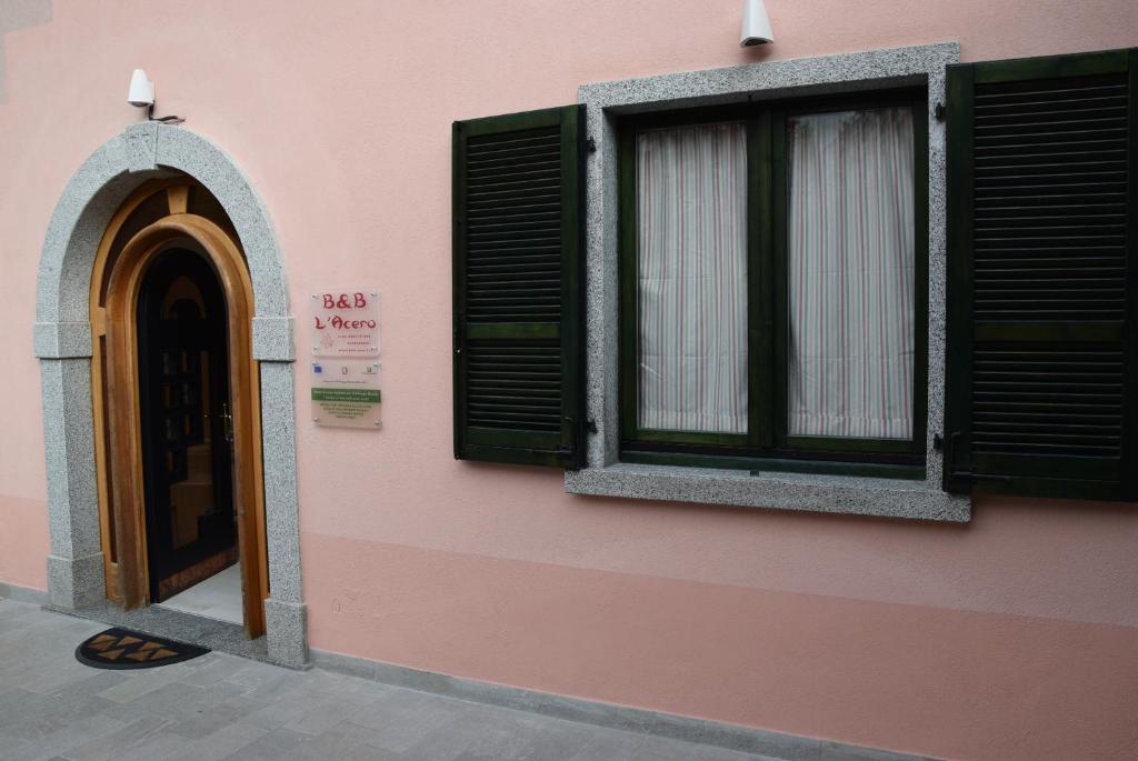 a pink building with a window and a door at B&B L'Acero in Casto