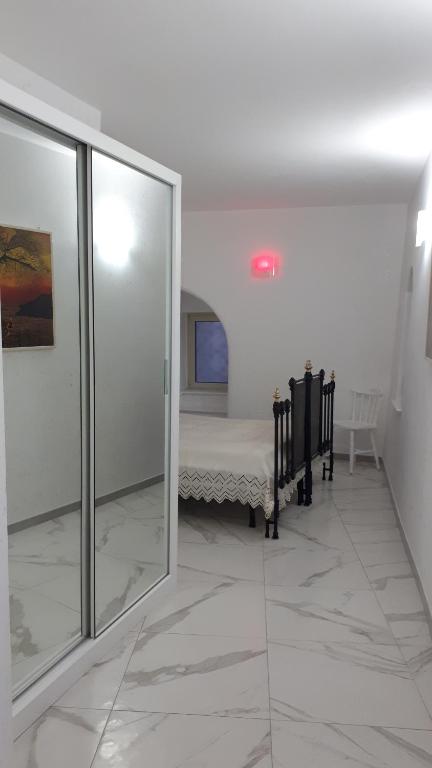Cette chambre comprend un lit et une porte en verre. dans l'établissement Azzurra, à Pizzo