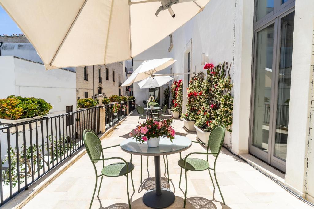a patio with tables and chairs on a balcony at Palazzo Indelli in Monopoli
