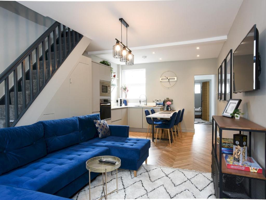 sala de estar con sofá azul y cocina en Pass the Keys Newly refurbed 3Bed 2Bath house in Central Portsmouth en Portsmouth