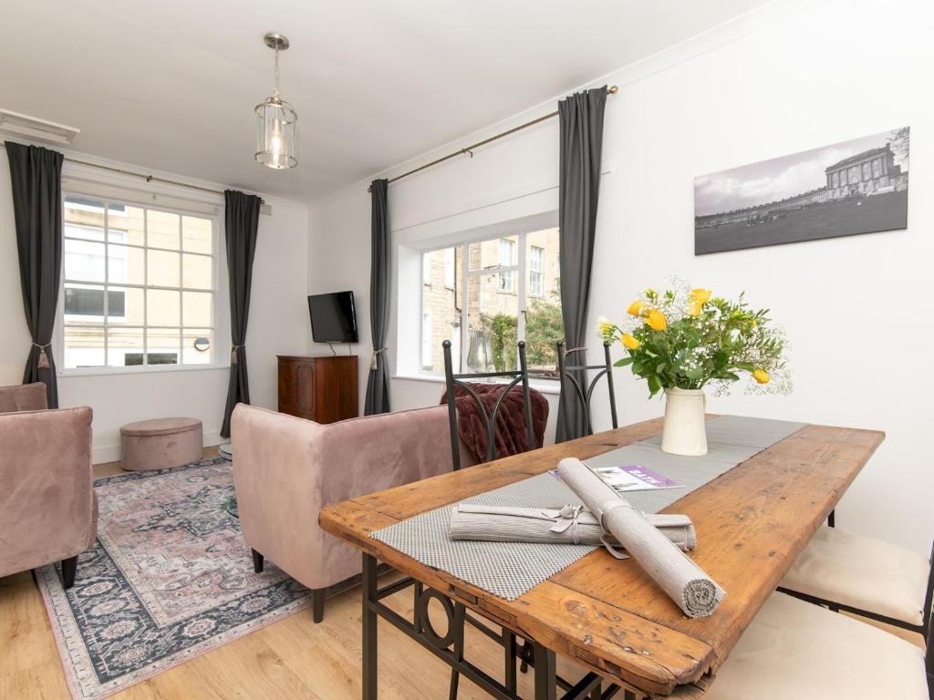 een woonkamer met een tafel en stoelen bij Pass the Keys Stylish 2 Bed central Bath Apartment with Parking in Bath