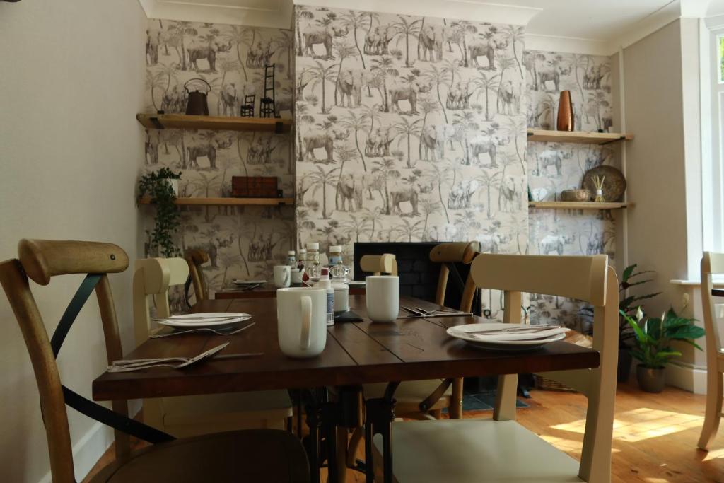 a dining room with a wooden table and chairs at Avonlea Guest House in Banbury