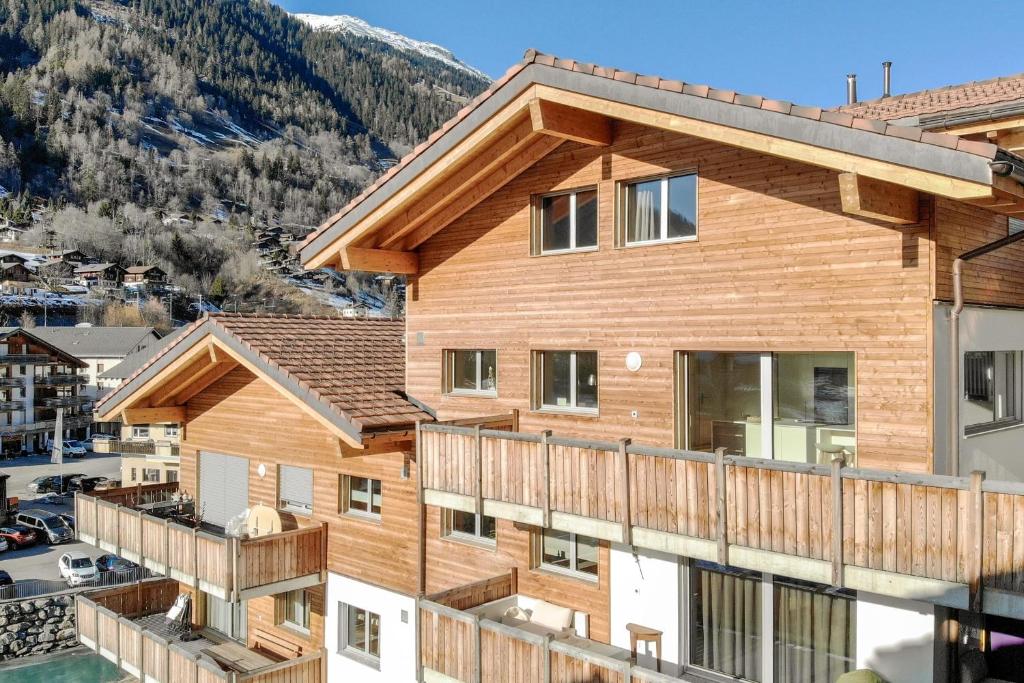 an apartment building with a deck and mountains in the background at Milachra Penthouse in Fiesch